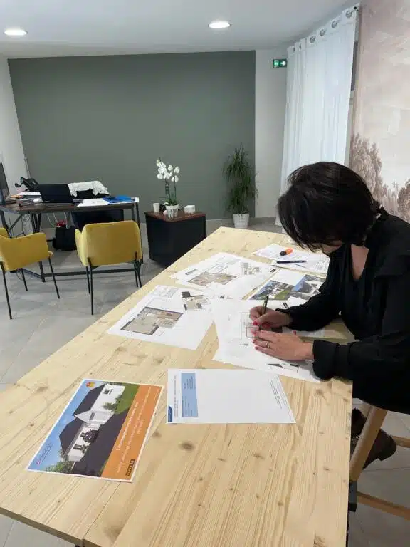Conseillère projet Océane Habitat concevant les plans sur mesure d'une maison neuve en agence dans le Morbihan.